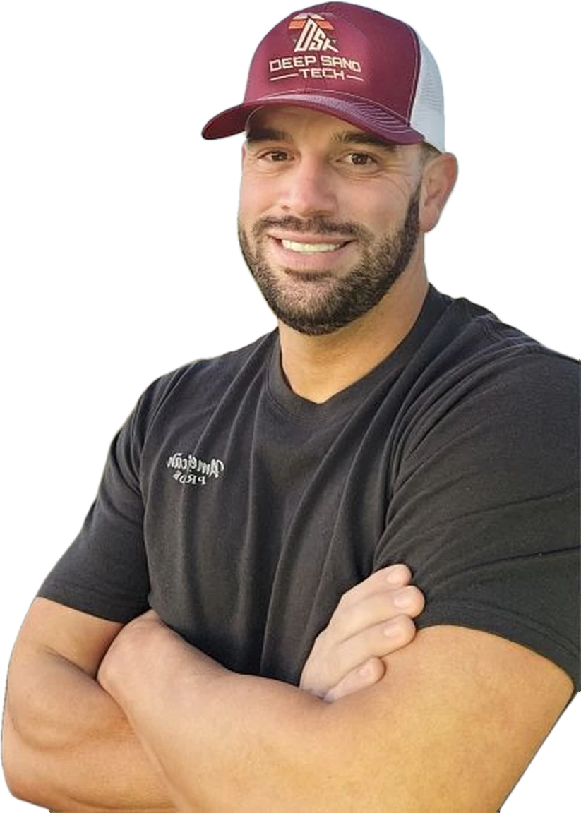 Joey Koebelen, Deep Sand Tech owner, in a maroon Deep Sand Tech cap with arms crossed